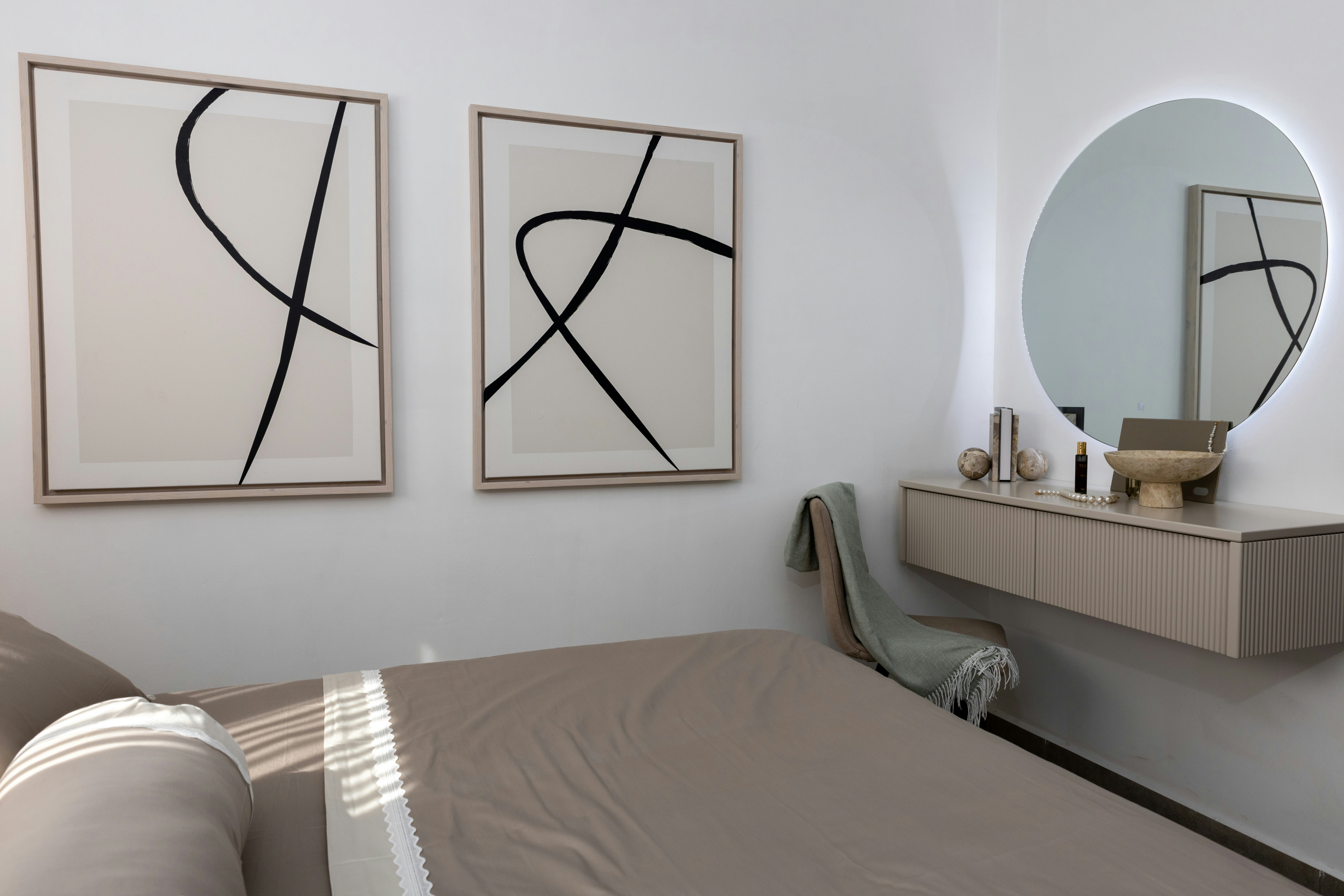 Minimalist bedroom with abstract art and vanity.